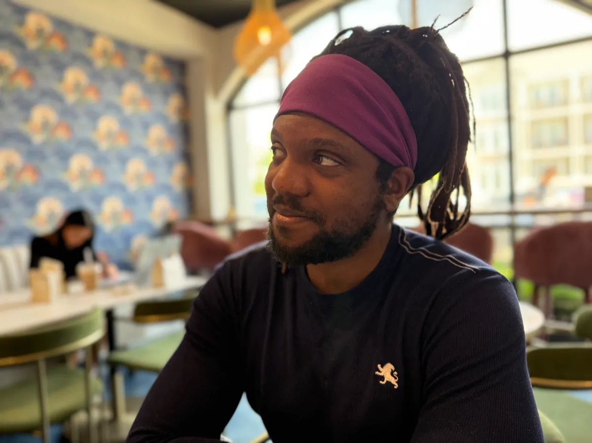 Thomas Edwards reflecting in a café