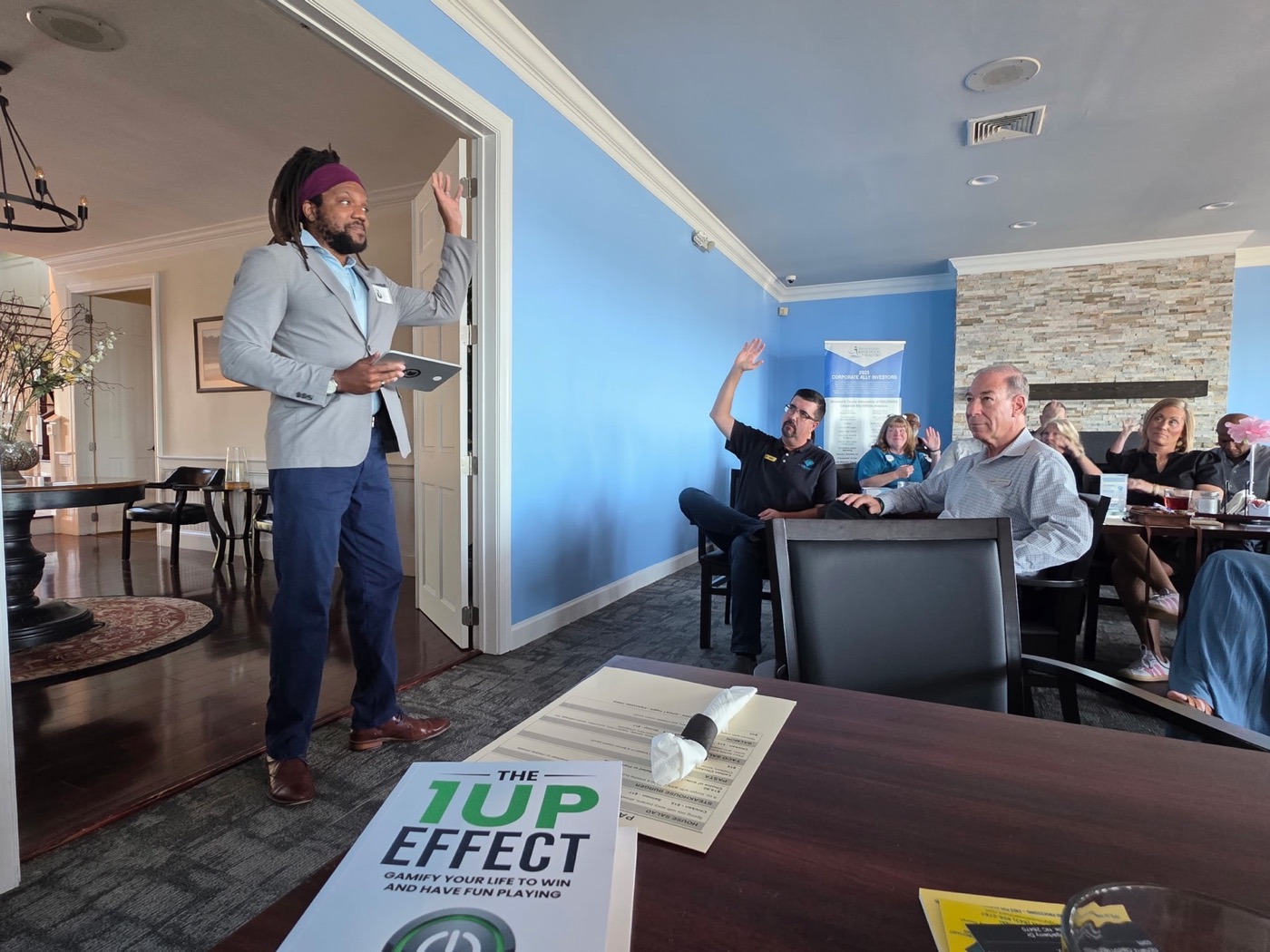 Thomas Edwards engaging an audience with copies of The 1UP Effect in the room